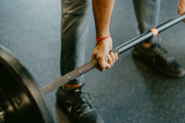 Close-up man lifting weights
